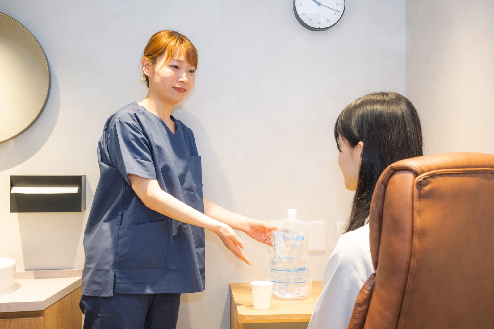 検査前の準備をご案内するスタッフ